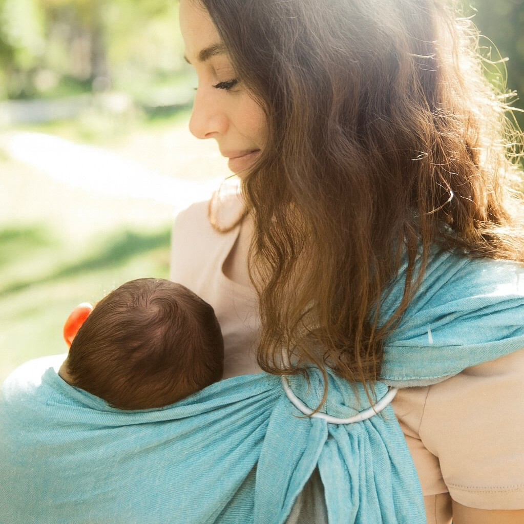 photo life style maman portant son bébé dans le sling bleu